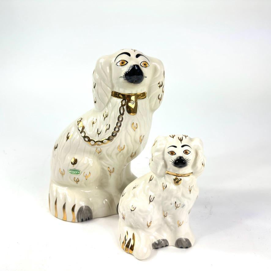 Vintage Beswick King Charles Spaniel pair, cream ceramic with hand-painted details, gilt collars and chain, displayed togethe