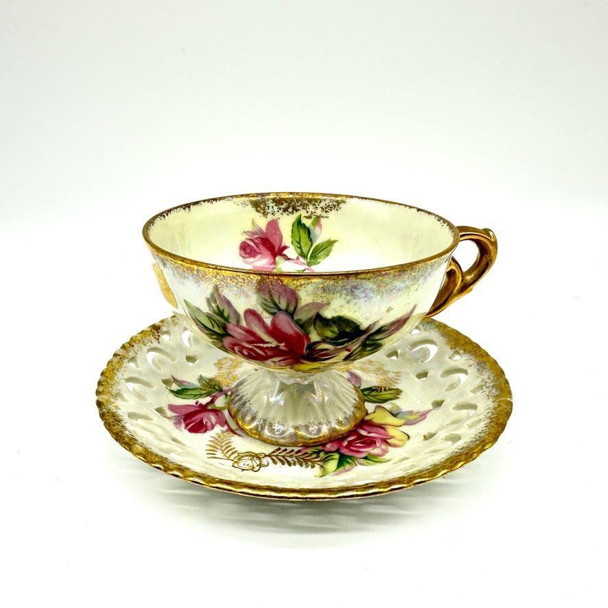 Vintage Chugai Japan teacup and saucer with pink rose design, gold trim, and pierced saucer detail, complete set view