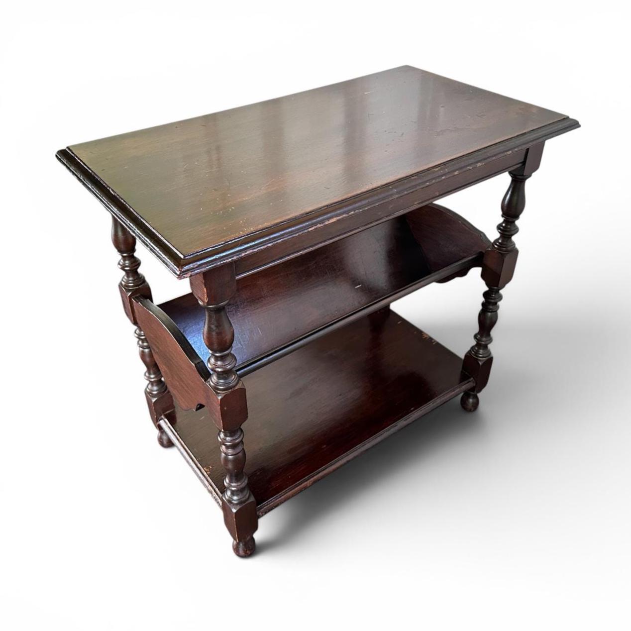 Vintage dark wood table with three shelf levels, turned wooden supports, and protective glass surface detail