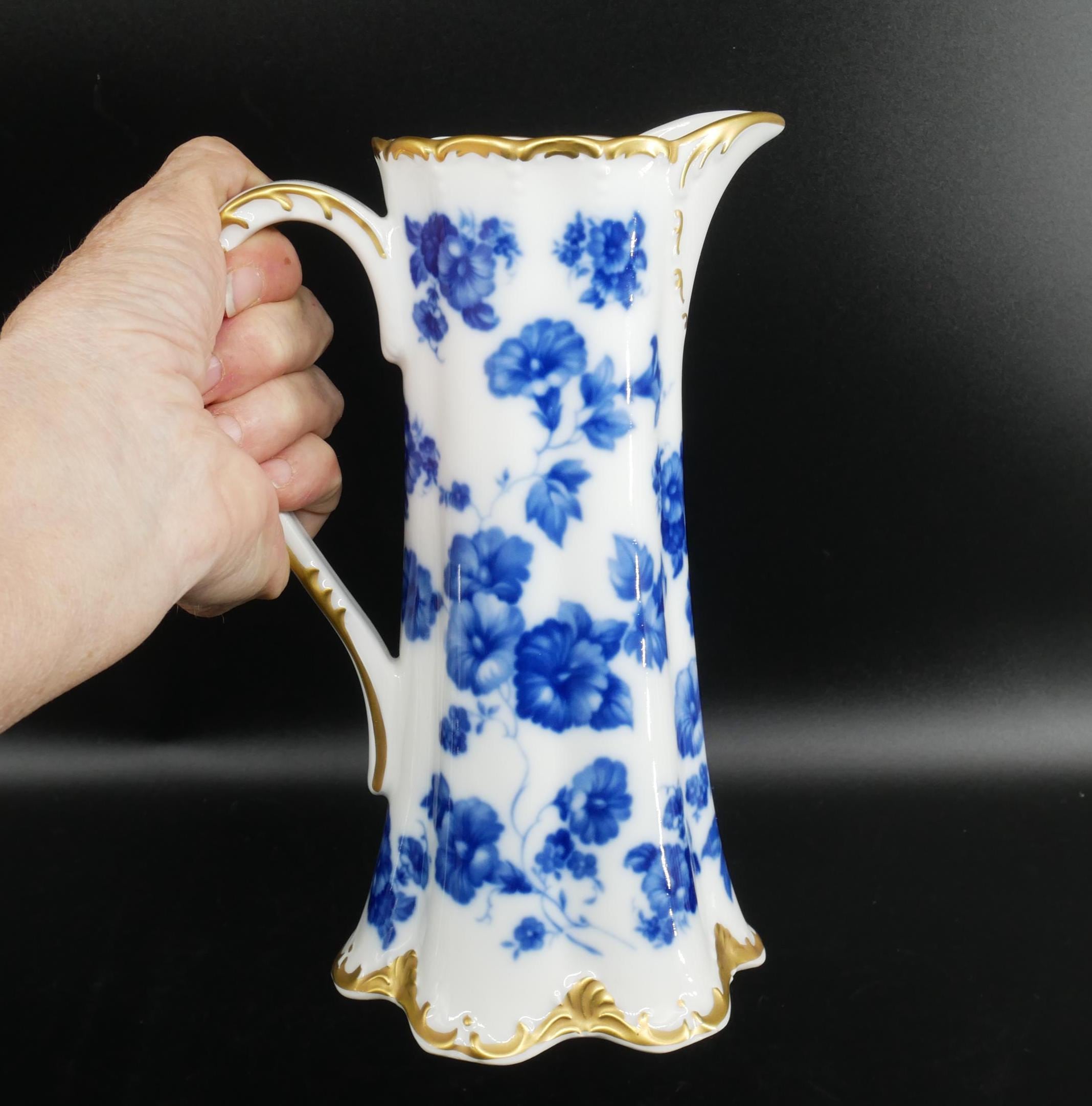 Vintage Gerold Porzellan Bavaria pitcher held in hand, white porcelain with cobalt blue floral pattern and gold-trimmed scall