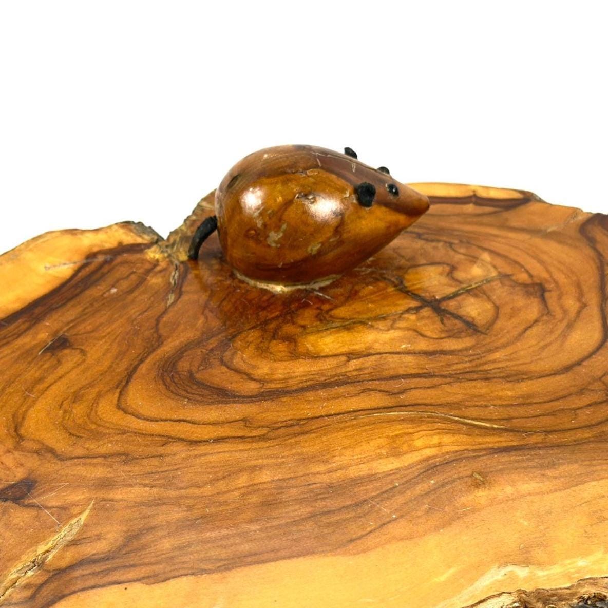 Vintage wood cheese board with live edge and hand-carved mouse detail, warm honey grain, three-quarter view