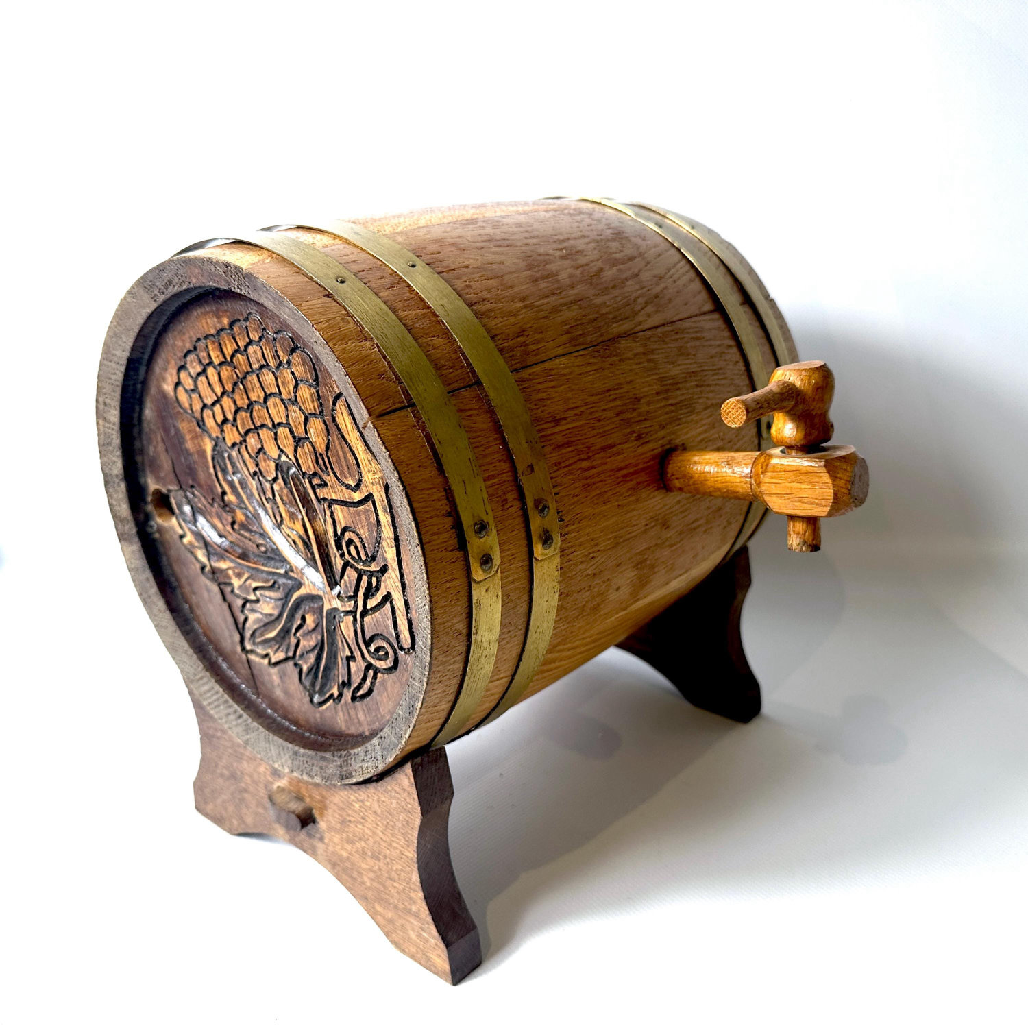 Wooden drinks barrel with brass bands, carved grape motif front, wooden tap, mounted on stand