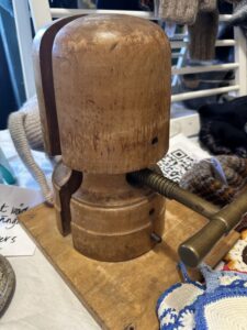 Vintage wooden fishing lure maker's head tool with rounded dome cap and turned base, displayed with workshop tools