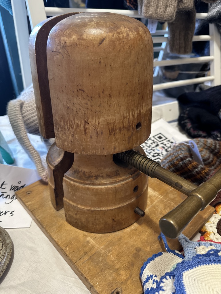 Vintage wooden fishing lure maker's head tool with rounded dome cap and turned base, displayed with workshop tools