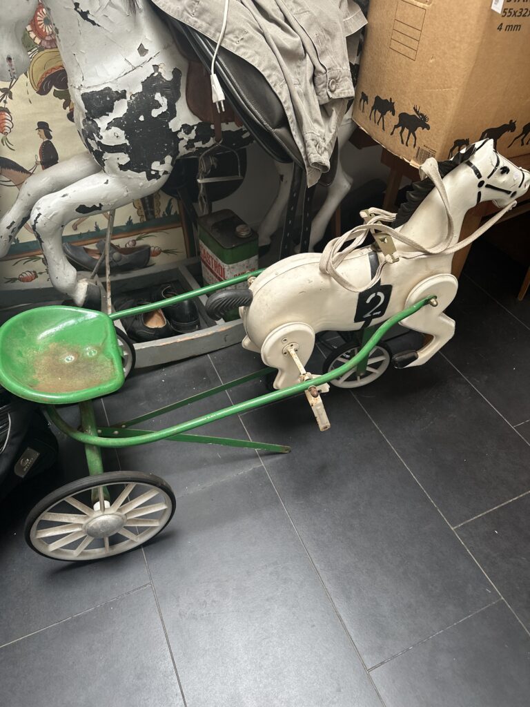 Vintage child's pram or carriage in cream and dark green with black wheels, ready for restoration