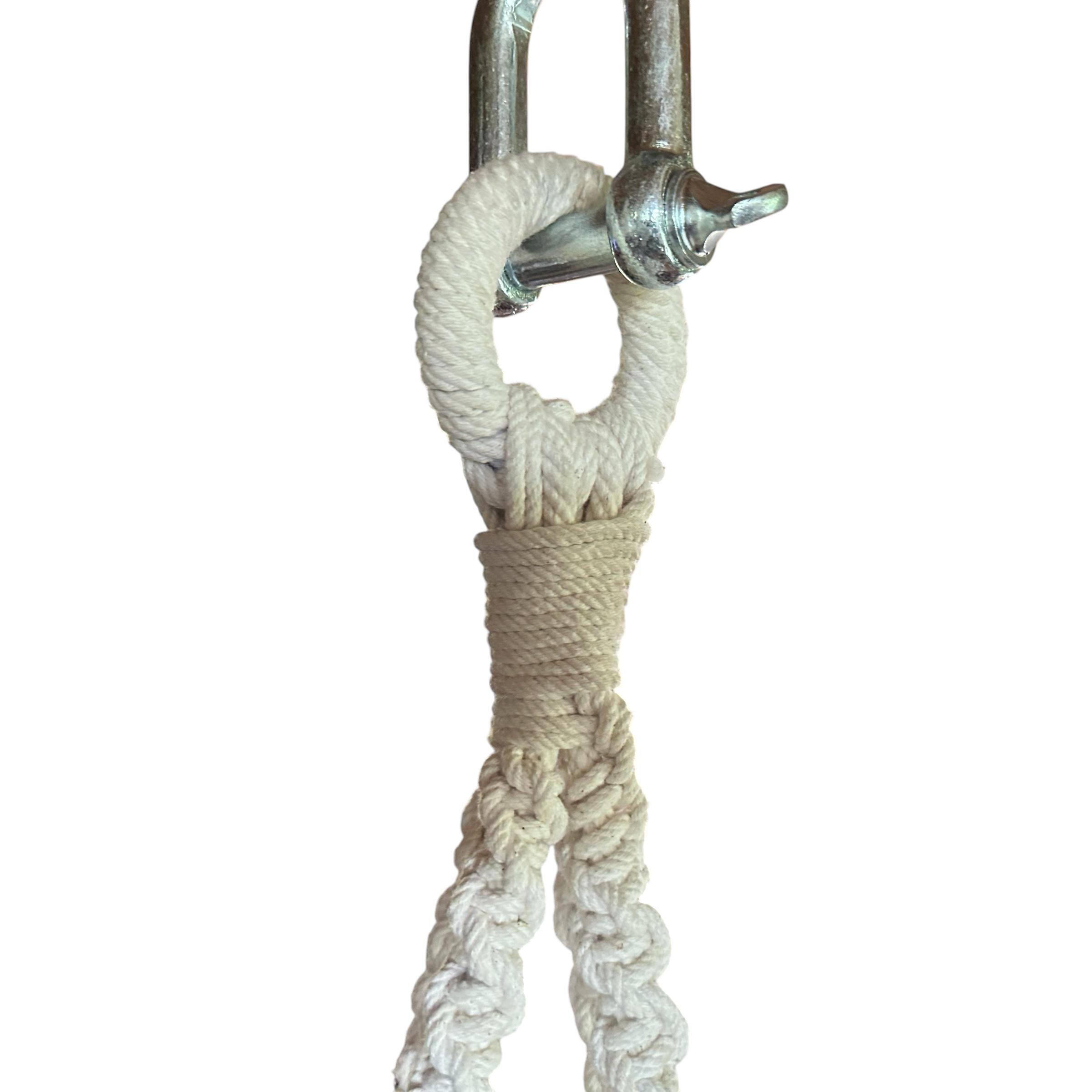 Close-up of metal hardware and cotton rope knot connection detail showing vintage hanging chair suspension mechanism