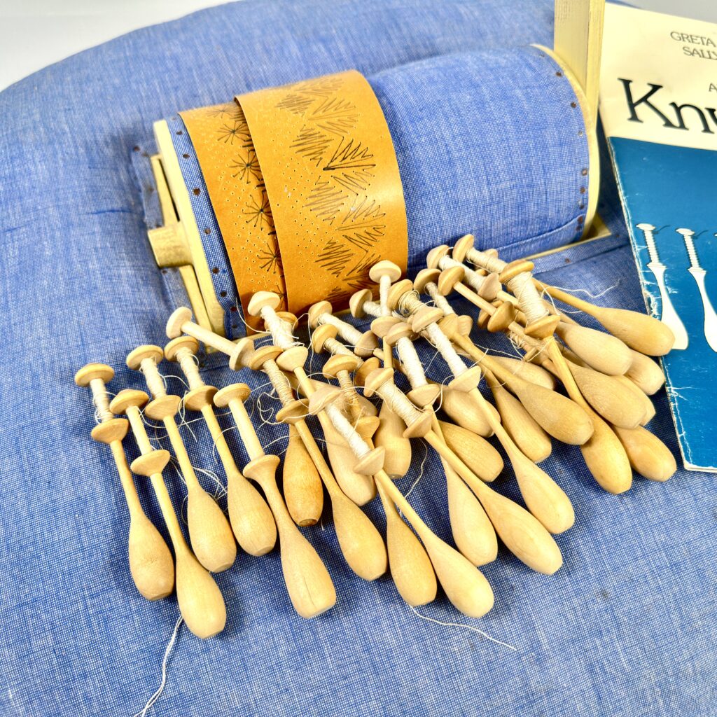 Collection of hand-carved wooden butter spreaders in natural birch or light wood with ornate handles, arranged in fan display