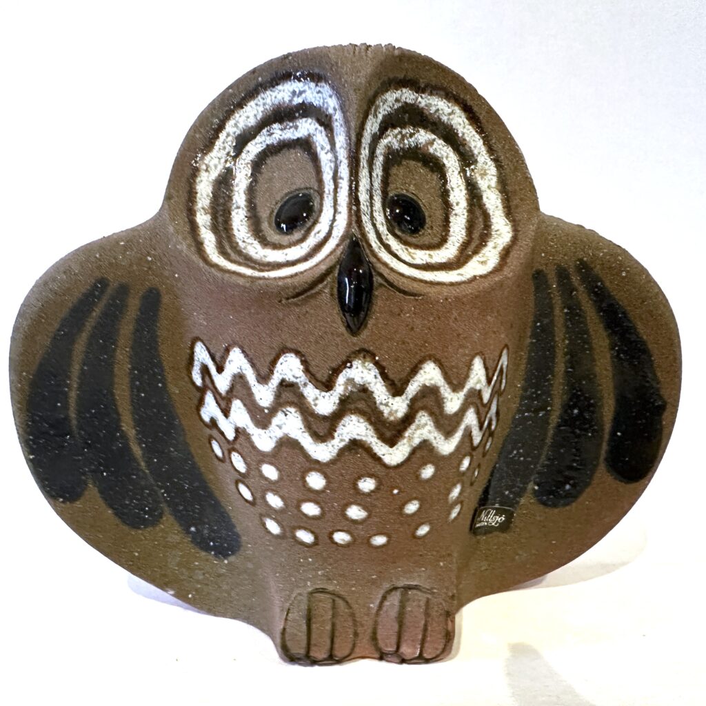 Ceramic owl figurine with dark glaze, white-lined eyes, and decorative dot patterns