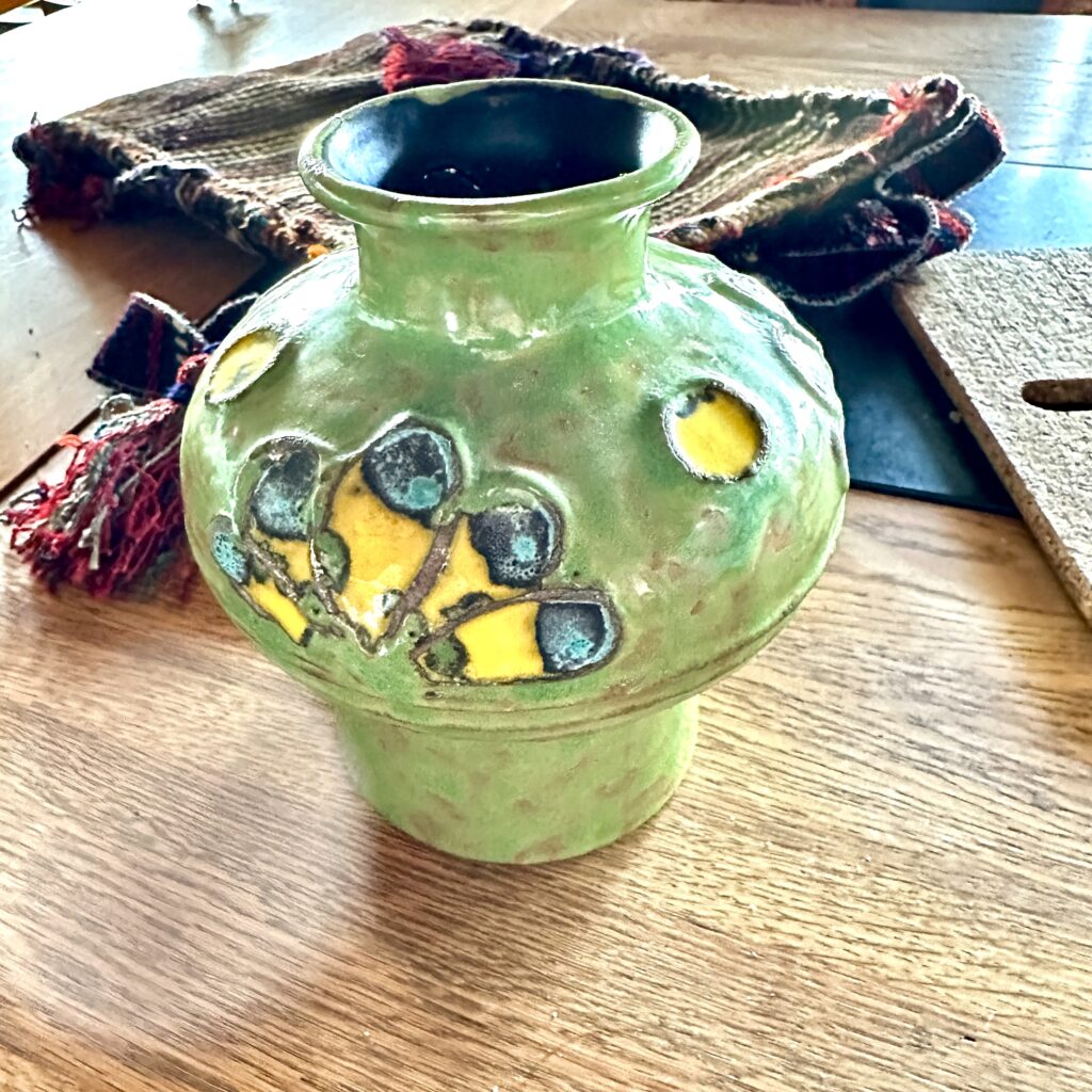 Moss-green German pottery vessel with abstract yellow and teal decorative accents, featuring natural stoneware glaze and orga