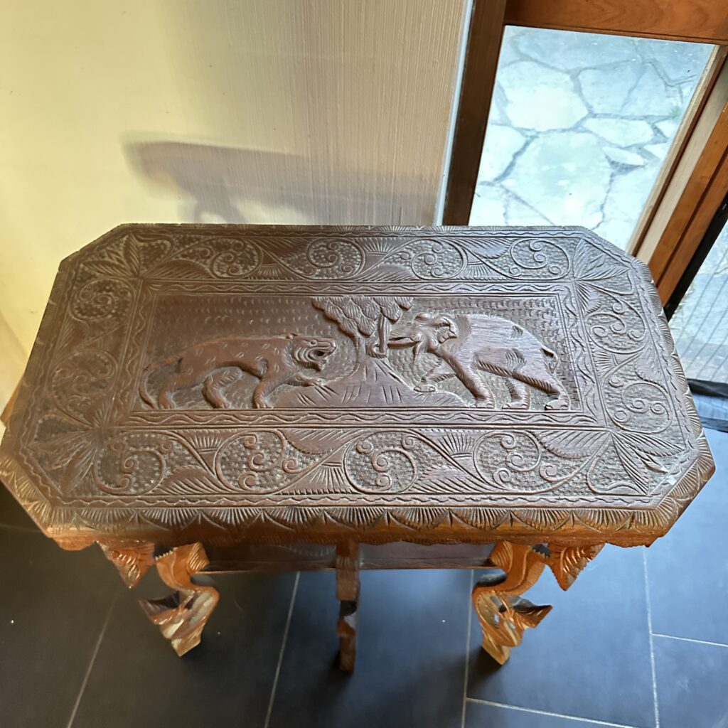 Close-up of ornamental carved wood table top showing detailed relief patterns and traditional craftsmanship